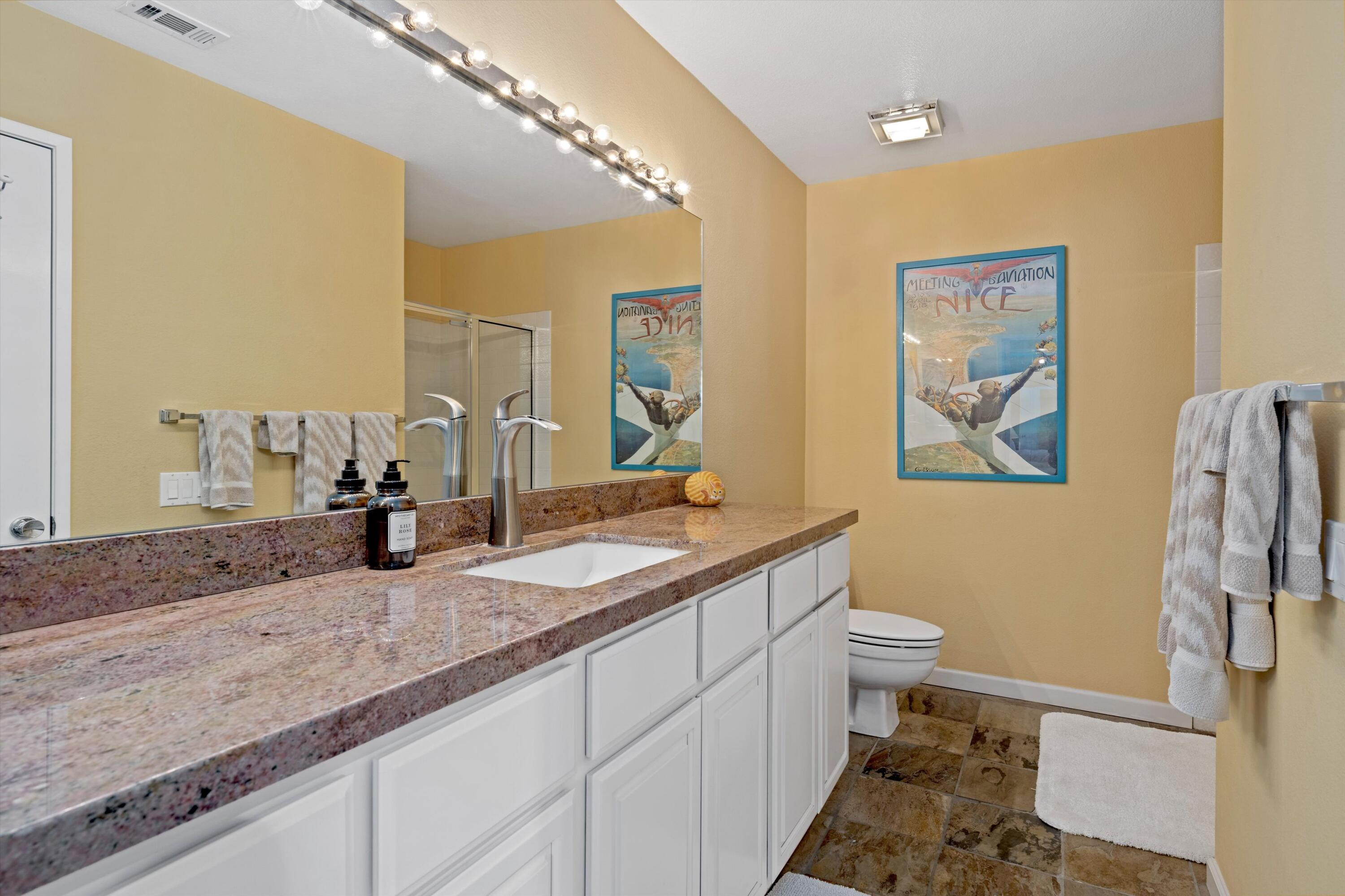 54053 Oak-Hill La Quinta, CA 92253 - Photo 21 of 36 a bathroom with a granite countertop sink mirror vanity and toilet
