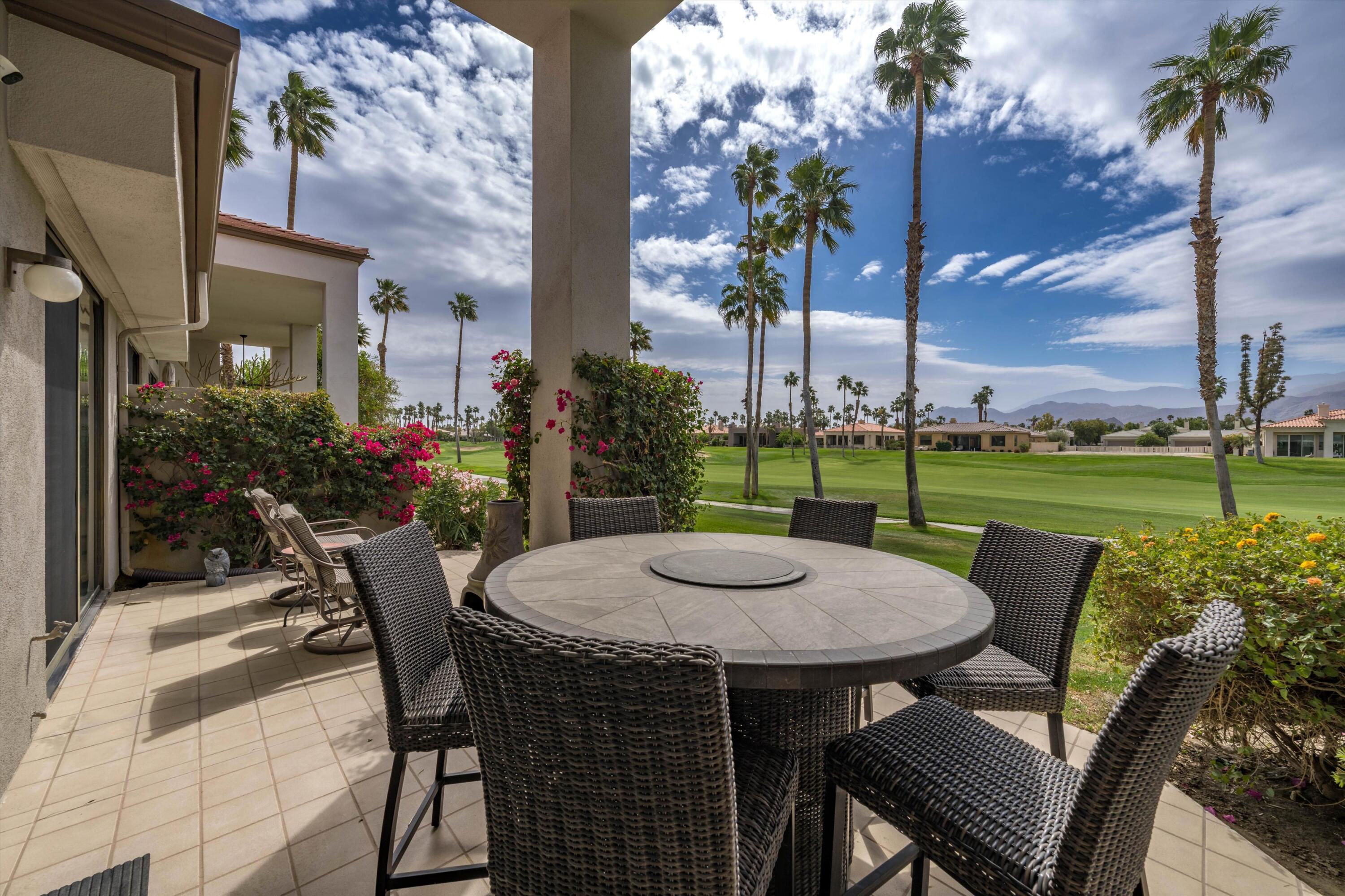 54053 Oak-Hill La Quinta, CA 92253 - Photo 25 of 36 a view of a patio with table and chairs potted plants and palm trees