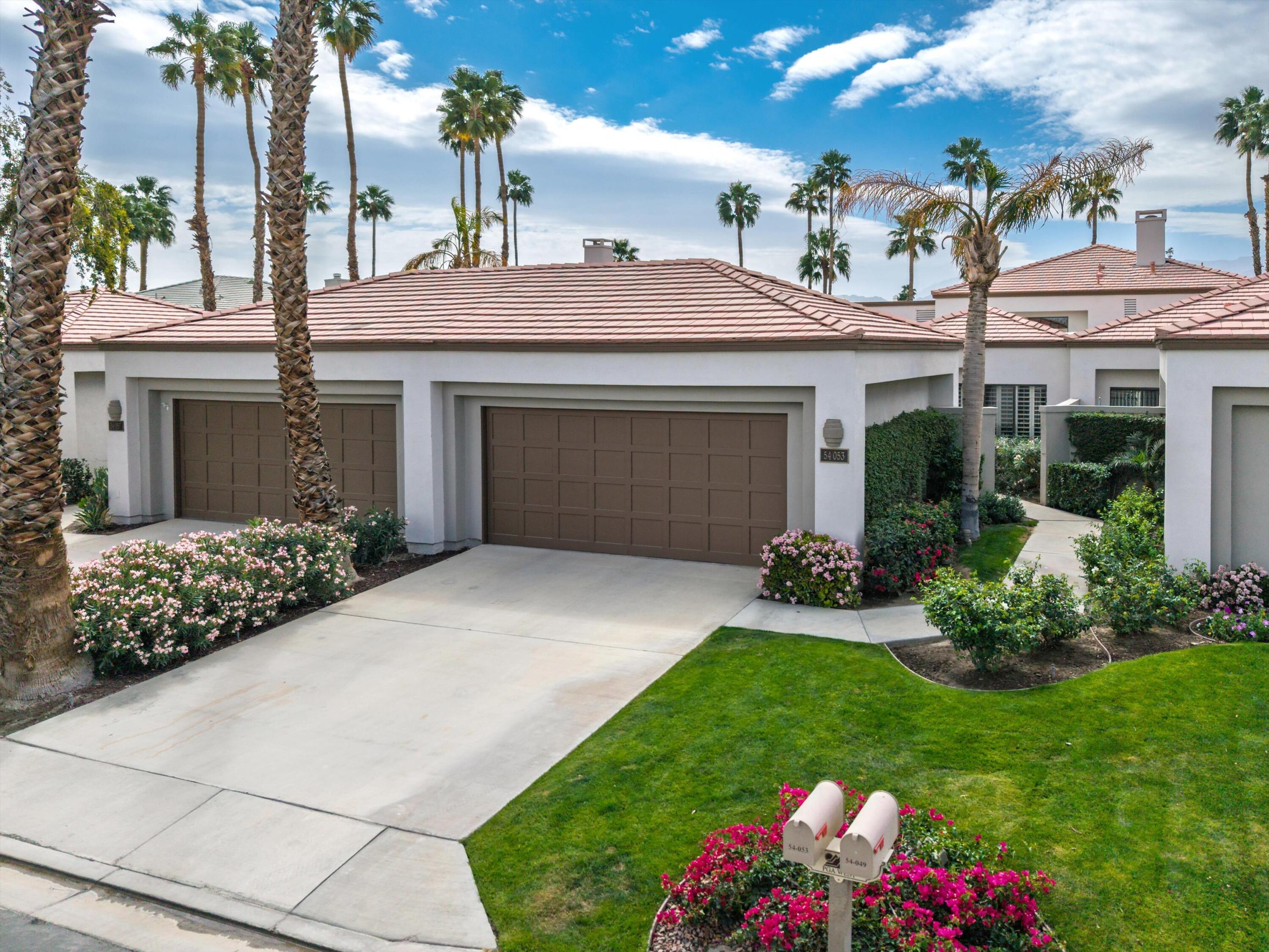 54053 Oak-Hill La Quinta, CA 92253 - Photo 29 of 36 a front view of a house with a garden and yard