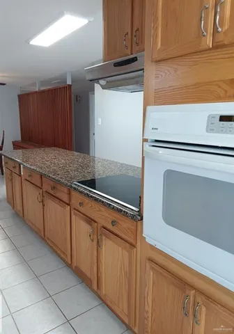 a kitchen with granite countertop cabinets and white appliances