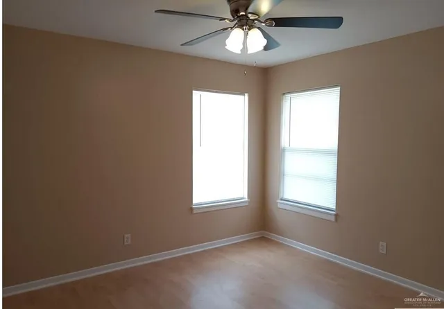 an empty room with a window and a fan