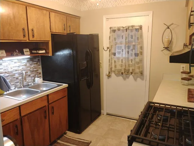 a kitchen with a refrigerator and a sink