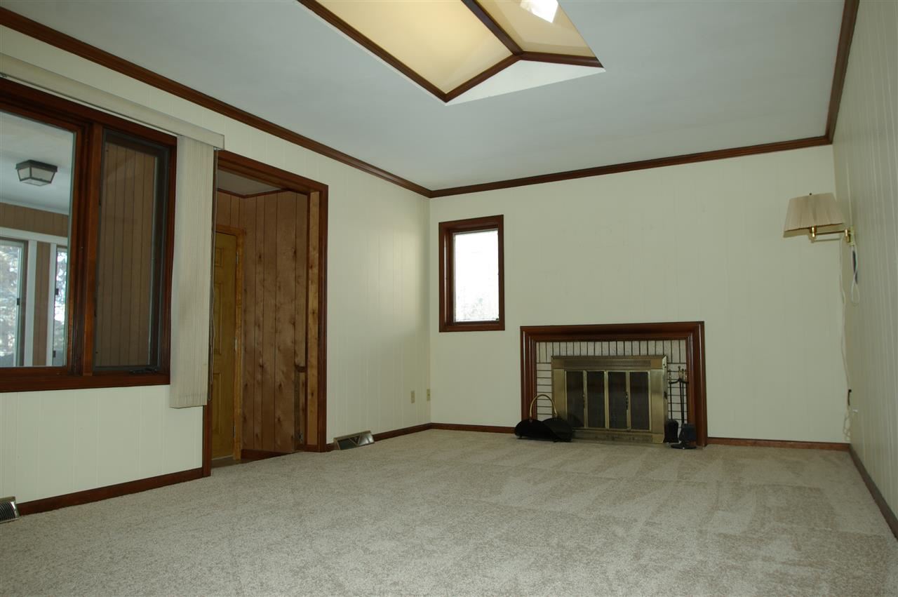 5460 Brookview Road Rockford, IL 61107 - Photo 8 of 20 an empty room with fireplace and a window