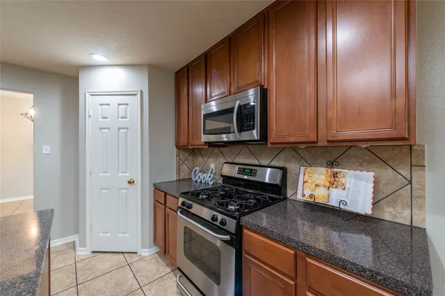 a kitchen with stainless steel appliances granite countertop a refrigerator and a stove top oven