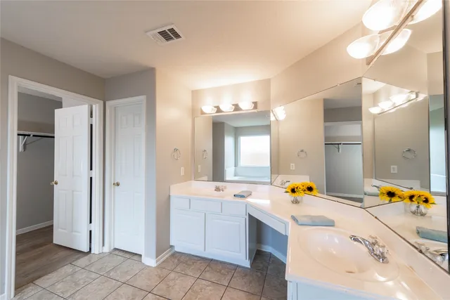 a bathroom with a tub sink and mirror
