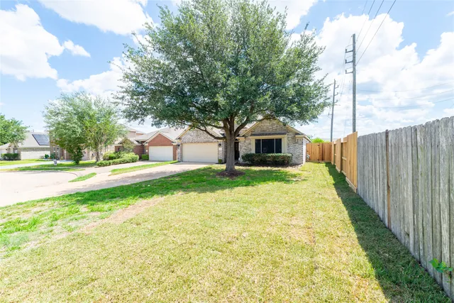 a view of house with backyard and tree
