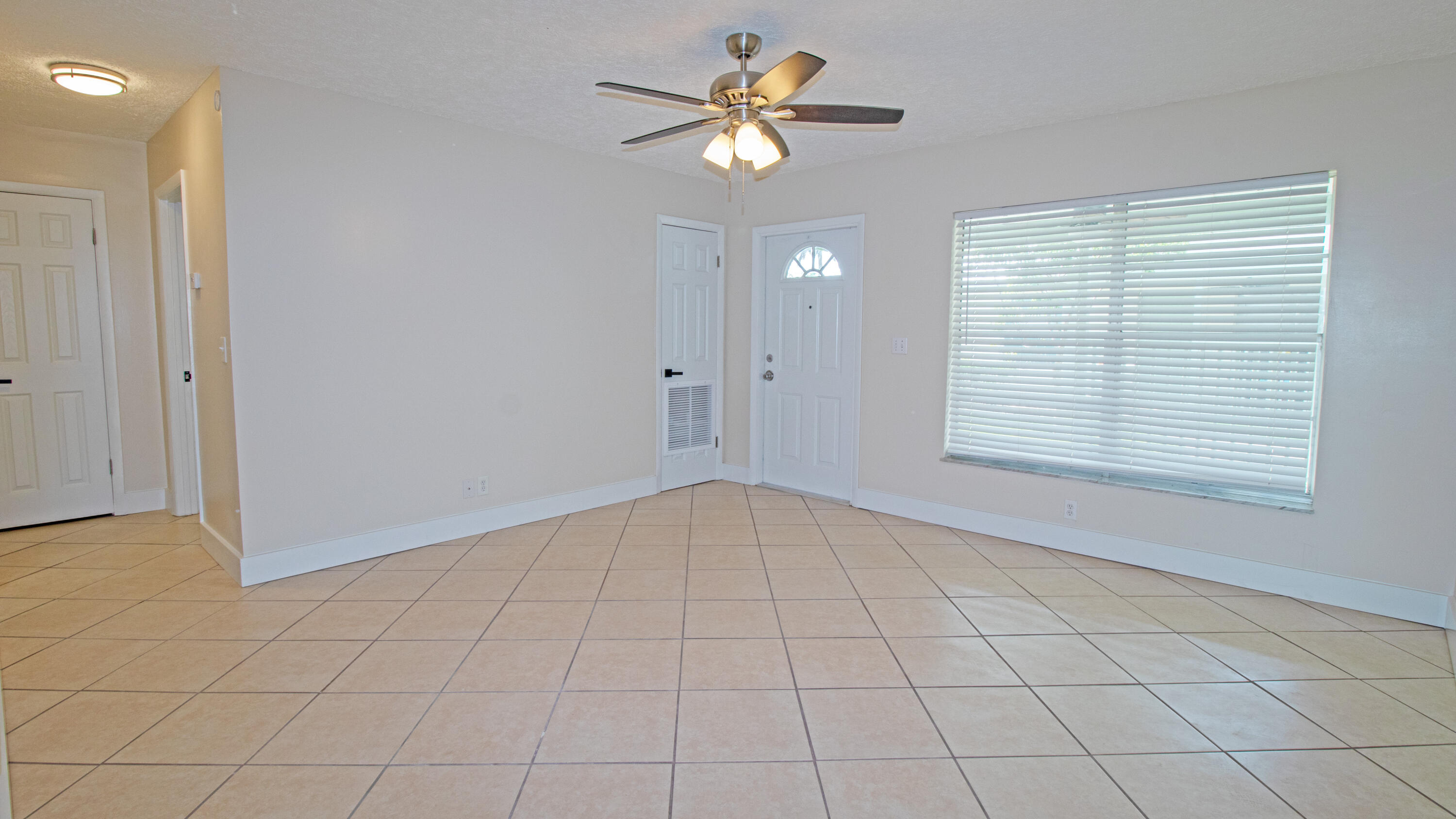 8757 Southeast Hobe Ridge Avenue Hobe Sound, FL 33455 - Photo 7 of 29 a view of an empty room with a window and a chandelier fan