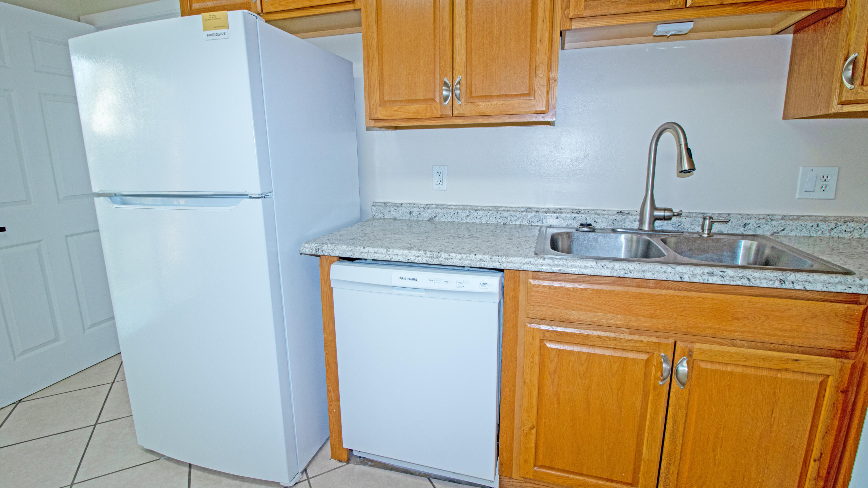 8757 Southeast Hobe Ridge Avenue Hobe Sound, FL 33455 - Photo 10 of 29 a kitchen with stainless steel appliances granite countertop a refrigerator and a sink