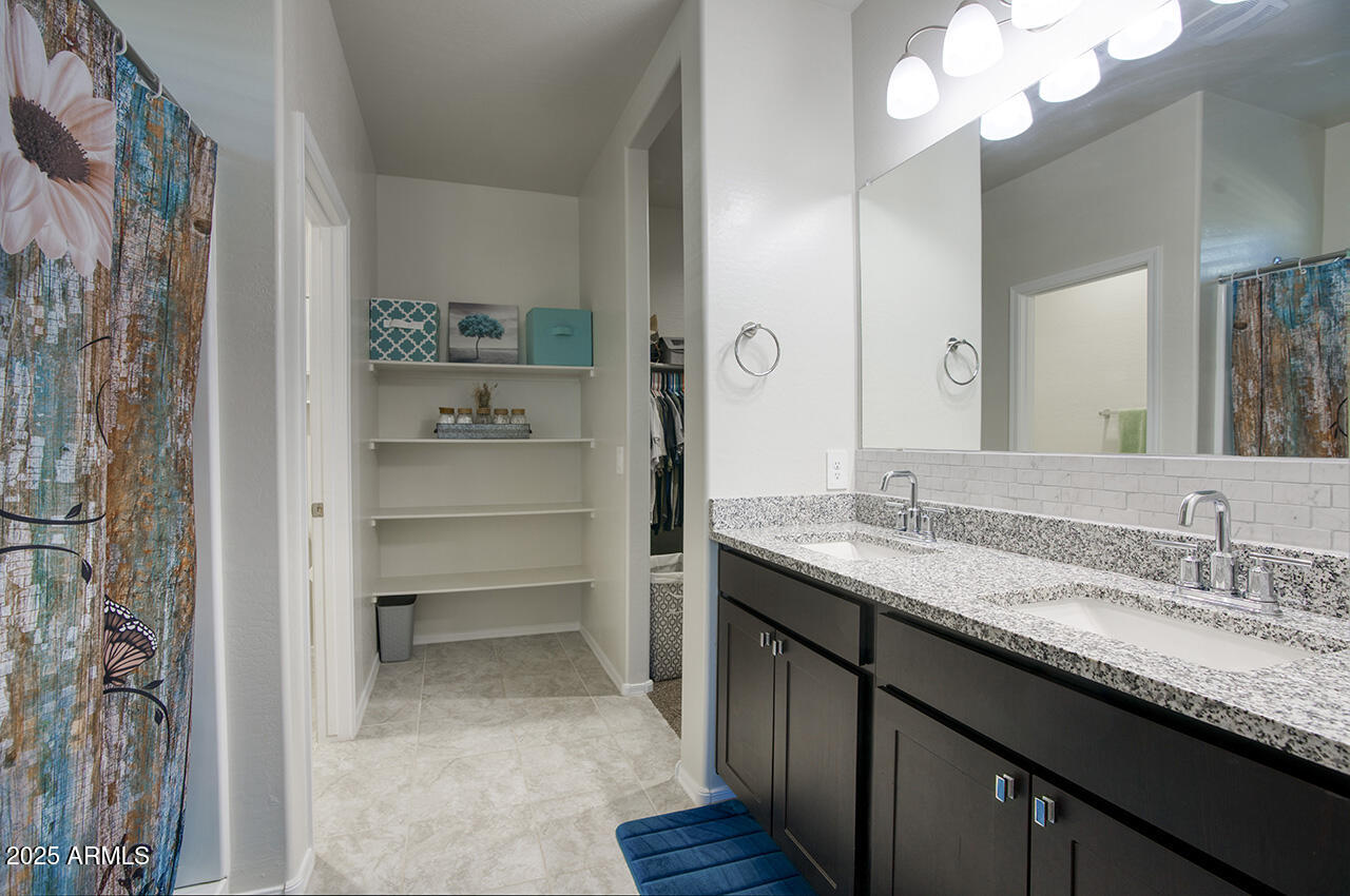 5236 East Emery Road San Tan Valley, AZ 85143 - Photo 14 of 24 a bathroom with a granite countertop sink a mirror and a shower