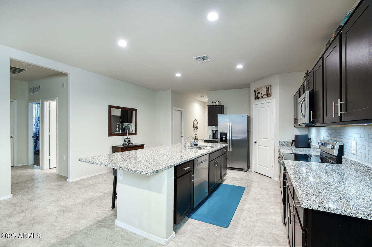 5236 East Emery Road San Tan Valley, AZ 85143 - Photo 6 of 24 a large kitchen with stainless steel appliances granite countertop plenty of counter top space a sink and cabinets