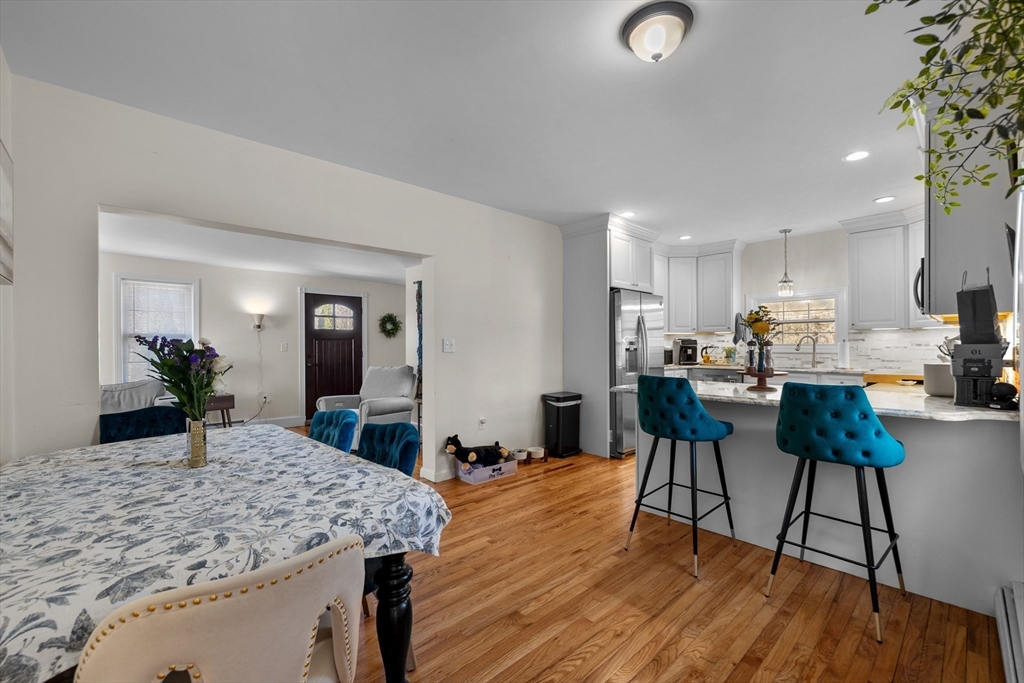 38 Brook Street Georgetown, MA 01833 - Photo 7 of 42 a kitchen with stainless steel appliances granite countertop a refrigerator a stove and a dining table with wooden floor
