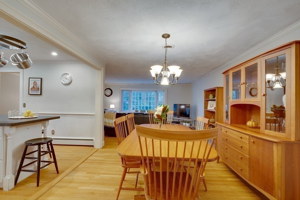11 Milepost Road Reading, MA 01867 - Photo 12 of 29 a view of a dining room with furniture a chandelier and wooden floor