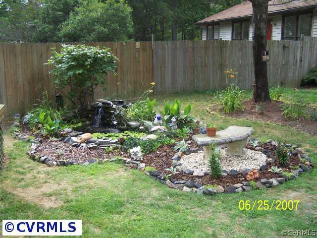 15816 Tri Gate Road Chester, VA 23831 - Photo 3 of 10 a view of a backyard with plants and a fountain