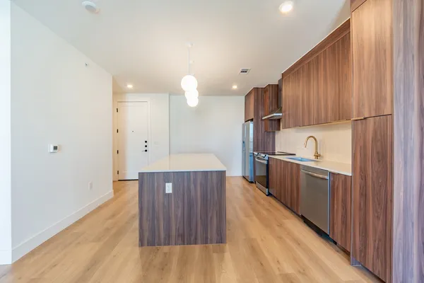a kitchen with stainless steel appliances granite countertop a sink refrigerator and cabinets