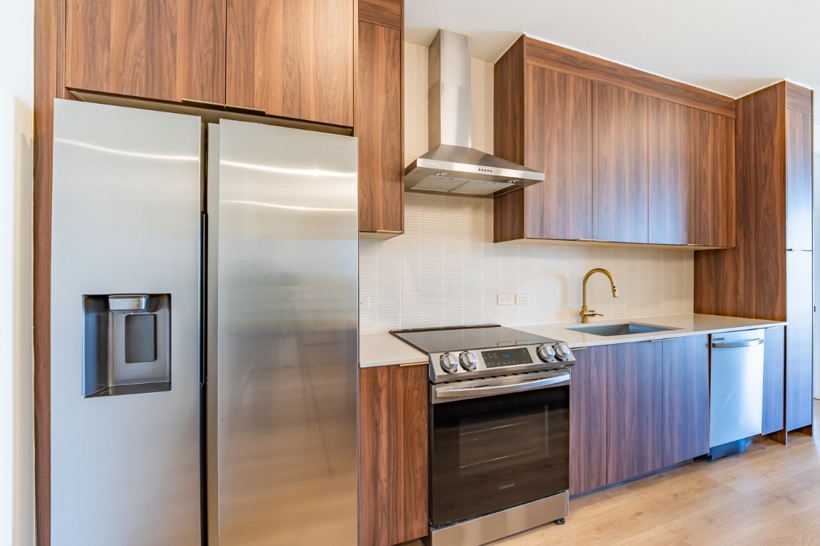 1701 Simond Avenue, Unit 611 Austin, TX 78723 - Photo 7 of 35 a kitchen with stainless steel appliances granite countertop a refrigerator a stove and a sink with wooden cabinets