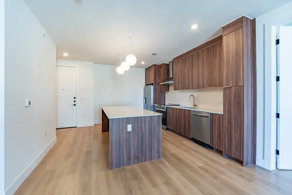 a kitchen with wooden floors and wooden cabinets