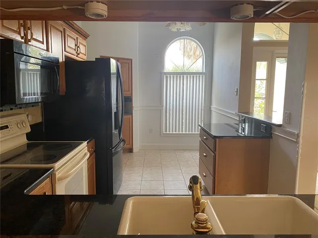 a kitchen with granite countertop a sink and a stove next to a window