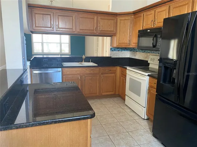 a kitchen with stainless steel appliances a refrigerator sink and white cabinets
