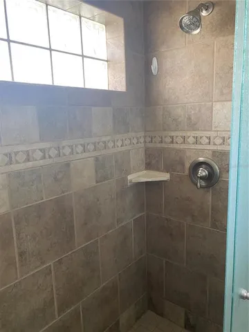 a view of an empty room with closet and mirror