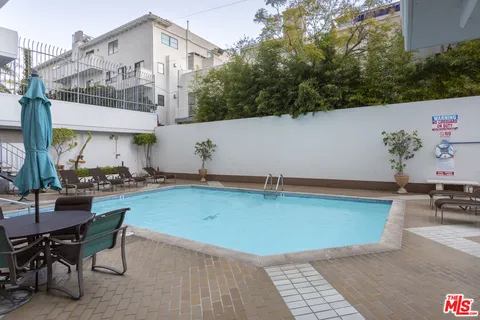 an outdoor space with swimming pool and furniture