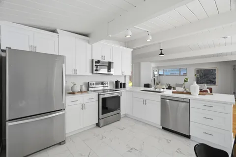 a kitchen with white cabinets and white appliances