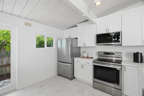 a kitchen with a stove a microwave and refrigerator