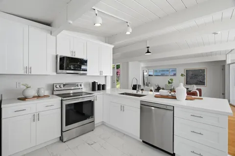 a kitchen with appliances a sink and cabinets