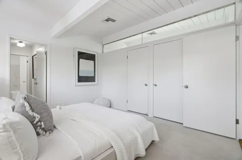 a bedroom with a bed and a painting on the wall