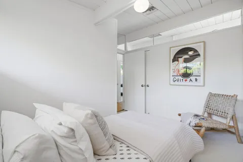 a bedroom with a bed and a painting on the wall