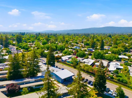 an aerial view of residential house with outdoor space and trees all around