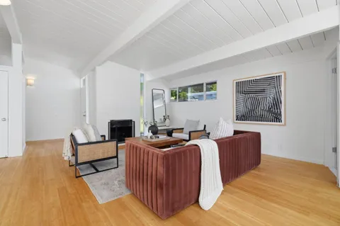 a living room with fireplace furniture and a wooden floor