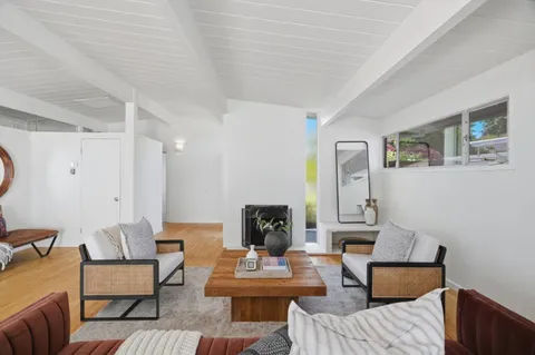 a living room with furniture and a wooden floor