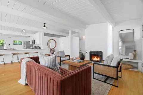 a living room with furniture a fireplace and a table