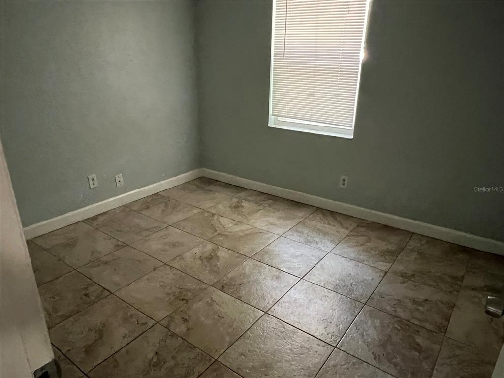 920 Maydell Drive, Unit B Tampa, FL 33619 - Photo 4 of 7 an empty room with a window