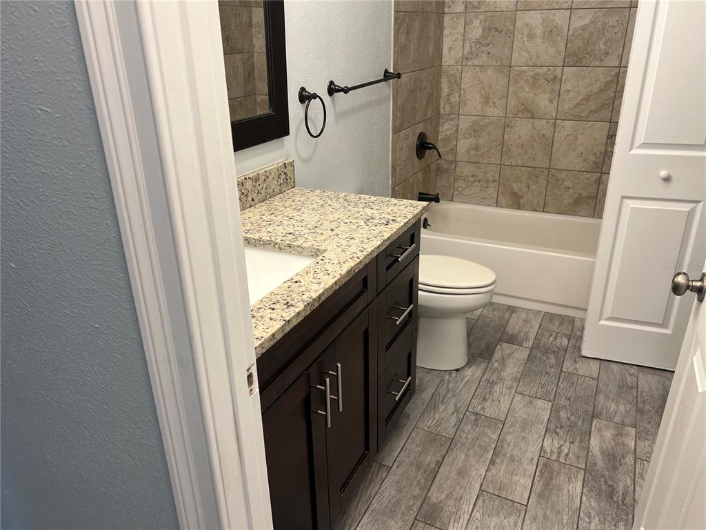 920 Maydell Drive, Unit B Tampa, FL 33619 - Photo 7 of 7 a bathroom with a granite countertop sink toilet and shower