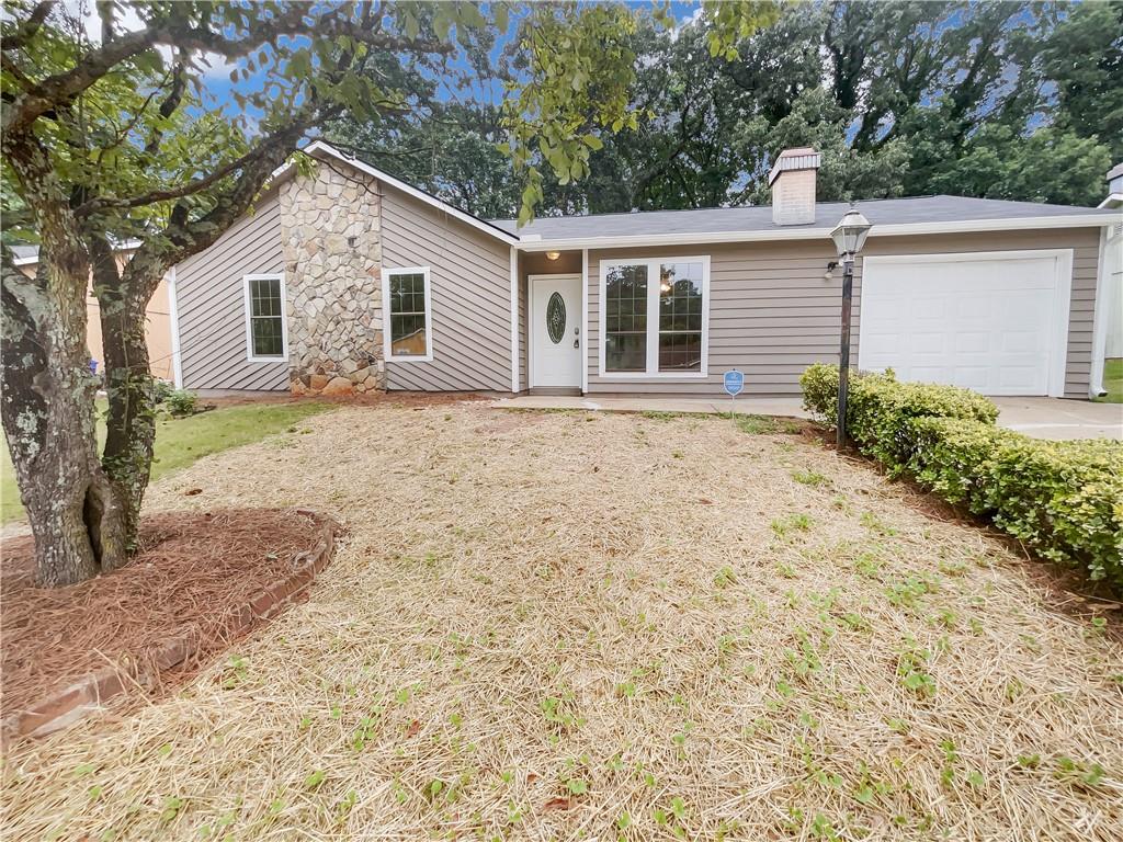 a view of a yard in front of a house with large trees