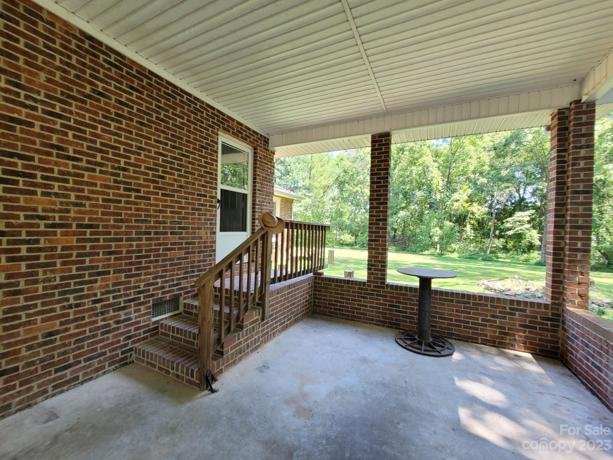 818 St Marks Church Road Bessemer City, NC 28016 - Photo 16 of 48 a view of a porch with wooden floor and roof with a garden