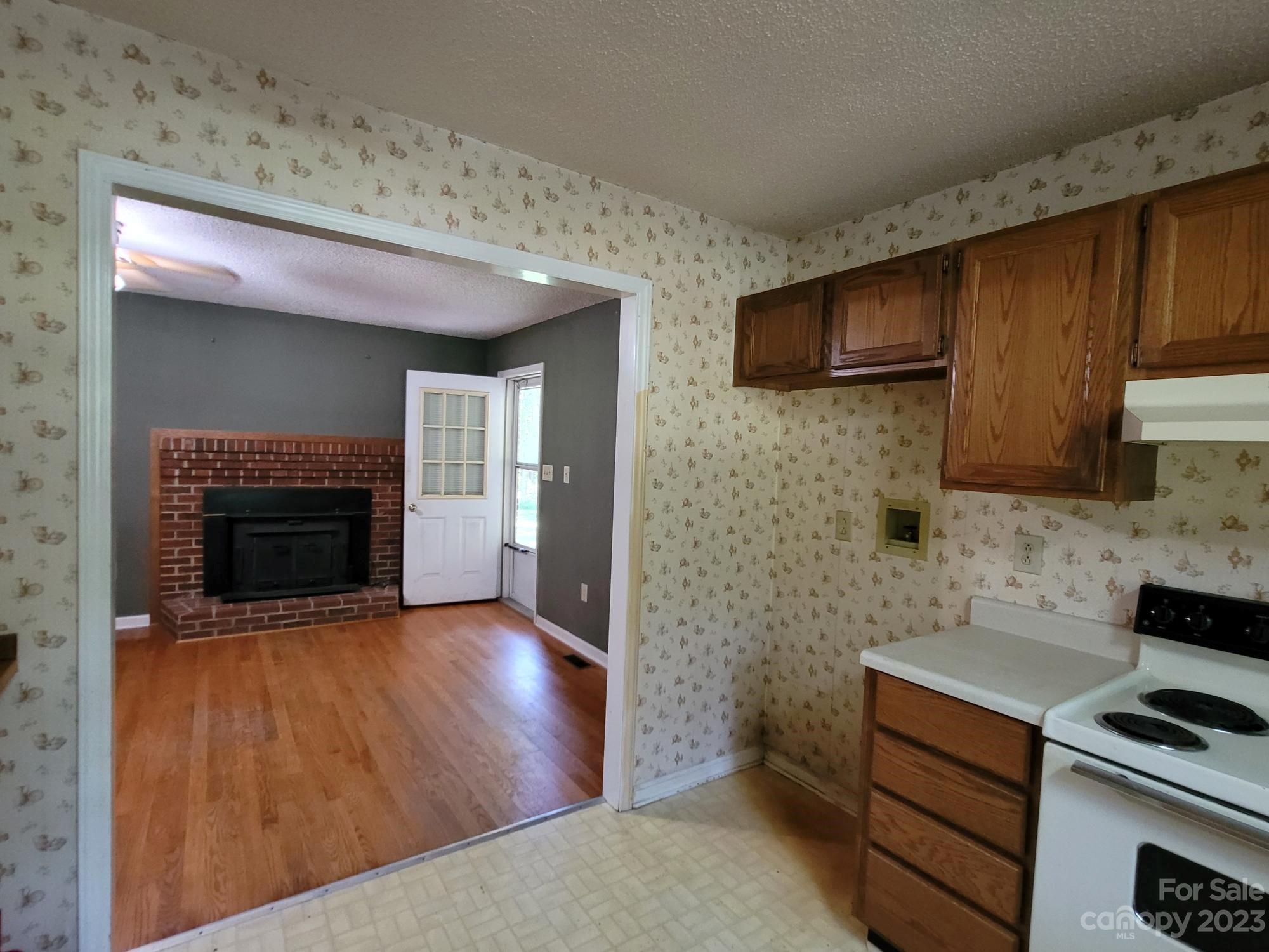 818 St Marks Church Road Bessemer City, NC 28016 - Photo 21 of 48 a kitchen with wooden floor and a fireplace