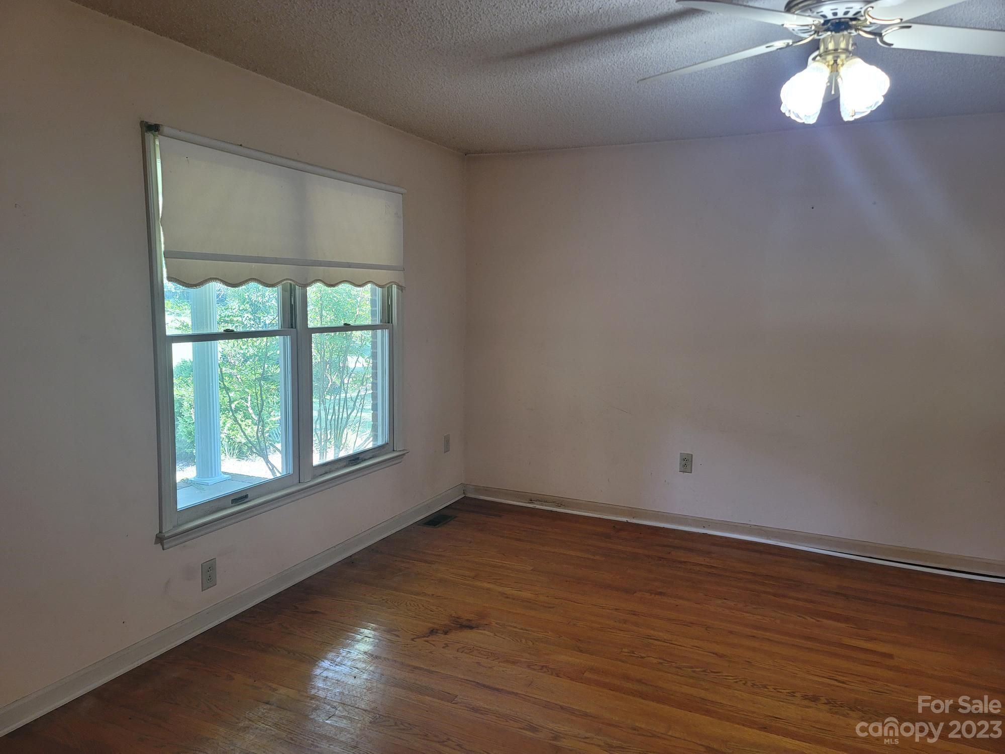 818 St Marks Church Road Bessemer City, NC 28016 - Photo 26 of 48 an empty room with wooden floor and windows