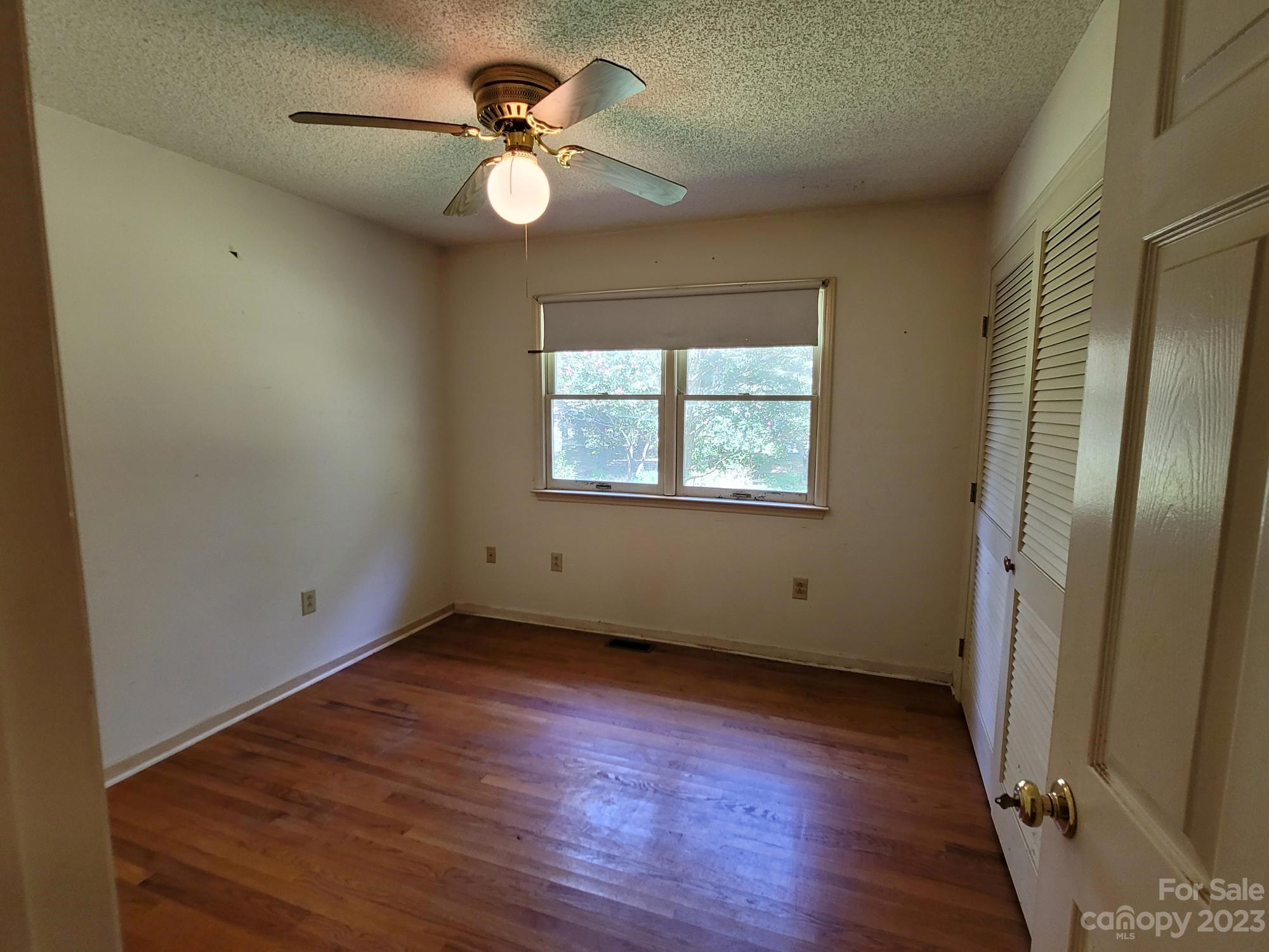 818 St Marks Church Road Bessemer City, NC 28016 - Photo 44 of 48 an empty room with wooden floor fan and windows