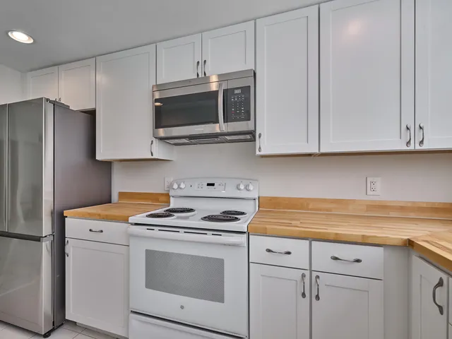 a view of kitchen with furniture refrigerator and wooden floor