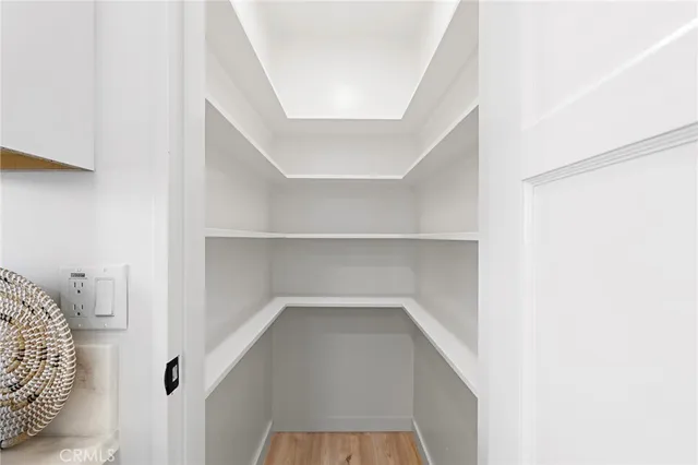 a bed room with a bed a chair and a potted plant