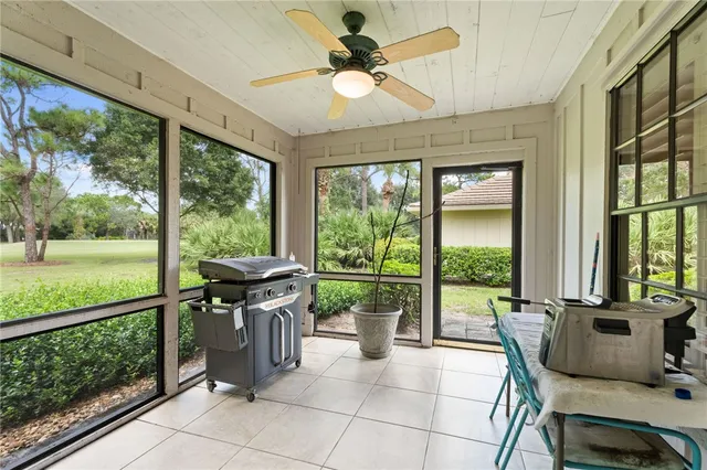 a living room with patio furniture and garden view