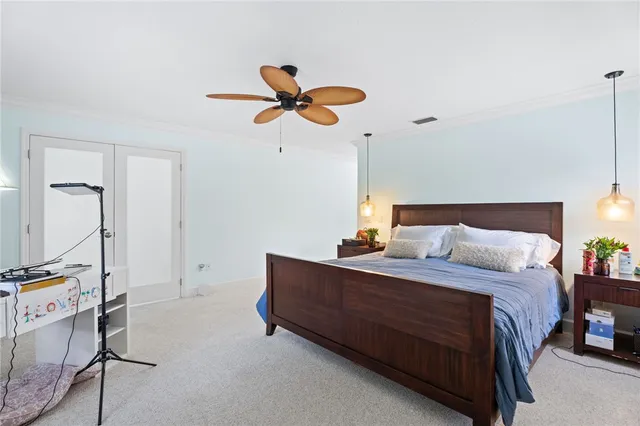 a bedroom with a bed a dresser and potted plants