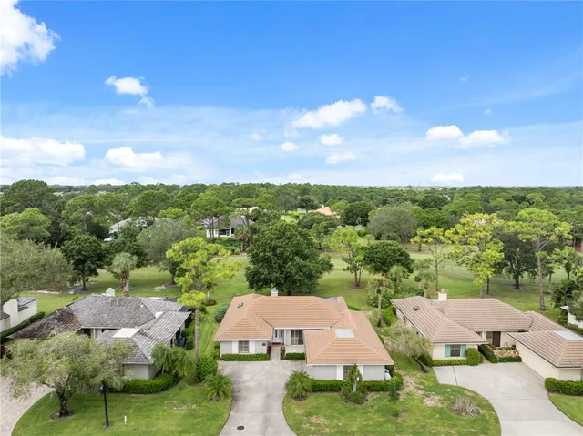 an aerial view of residential houses with outdoor space and trees
