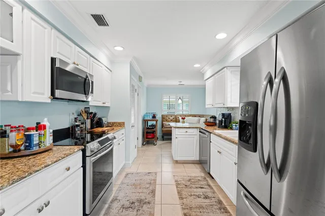 a kitchen with stainless steel appliances granite countertop a refrigerator sink and microwave