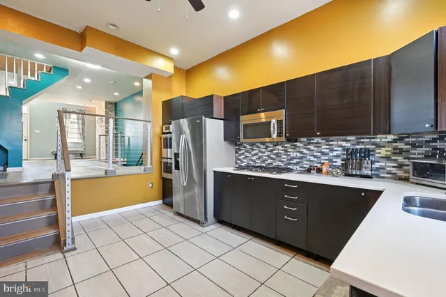a kitchen with stainless steel appliances a sink and a refrigerator