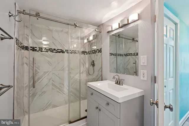 a bathroom with a shower sink and mirror