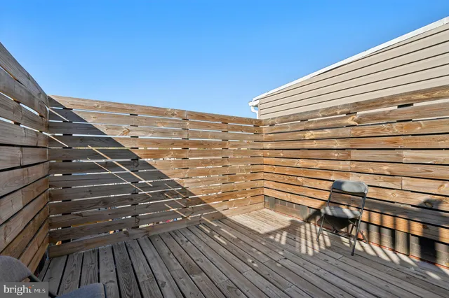 a view of a balcony with wooden floor and fence