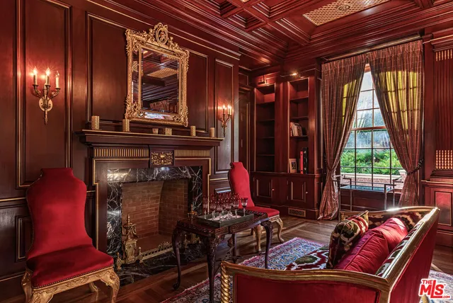 a living room with furniture chandelier and a fireplace